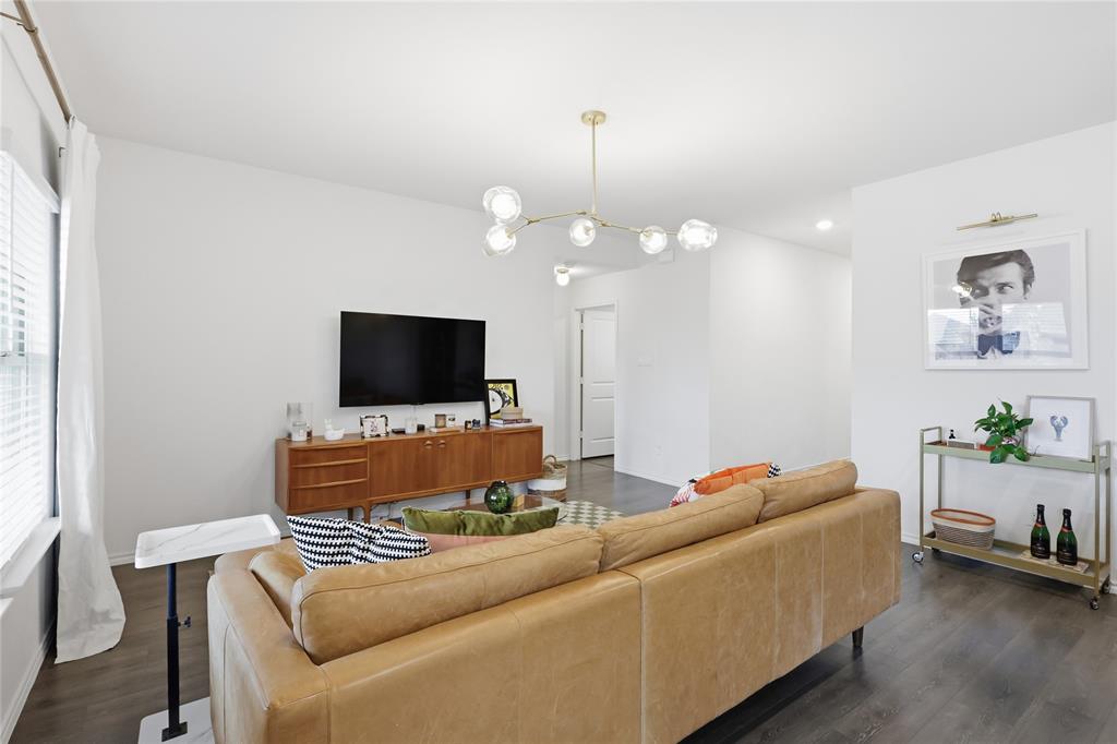 Living area featuring dark wood-finish flooring, a contemporary multi-globe chandelier, and recessed lighting