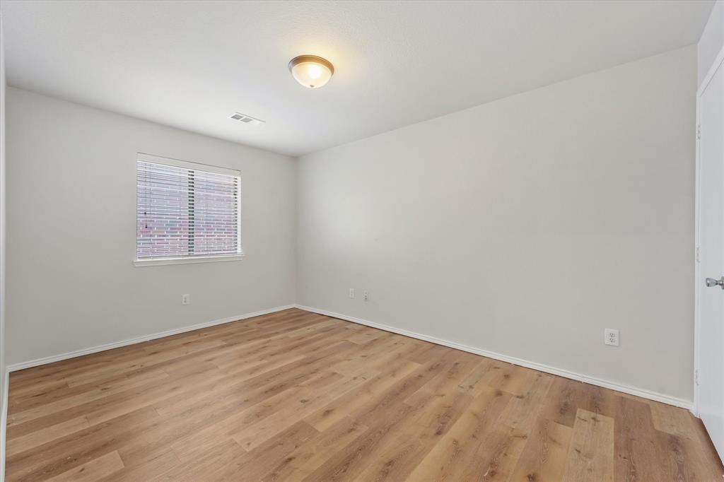 Neutral-toned walls, wood-finish flooring, and a single-pane window Neutral-toned walls, wood-finish flooring, and a single-pane window