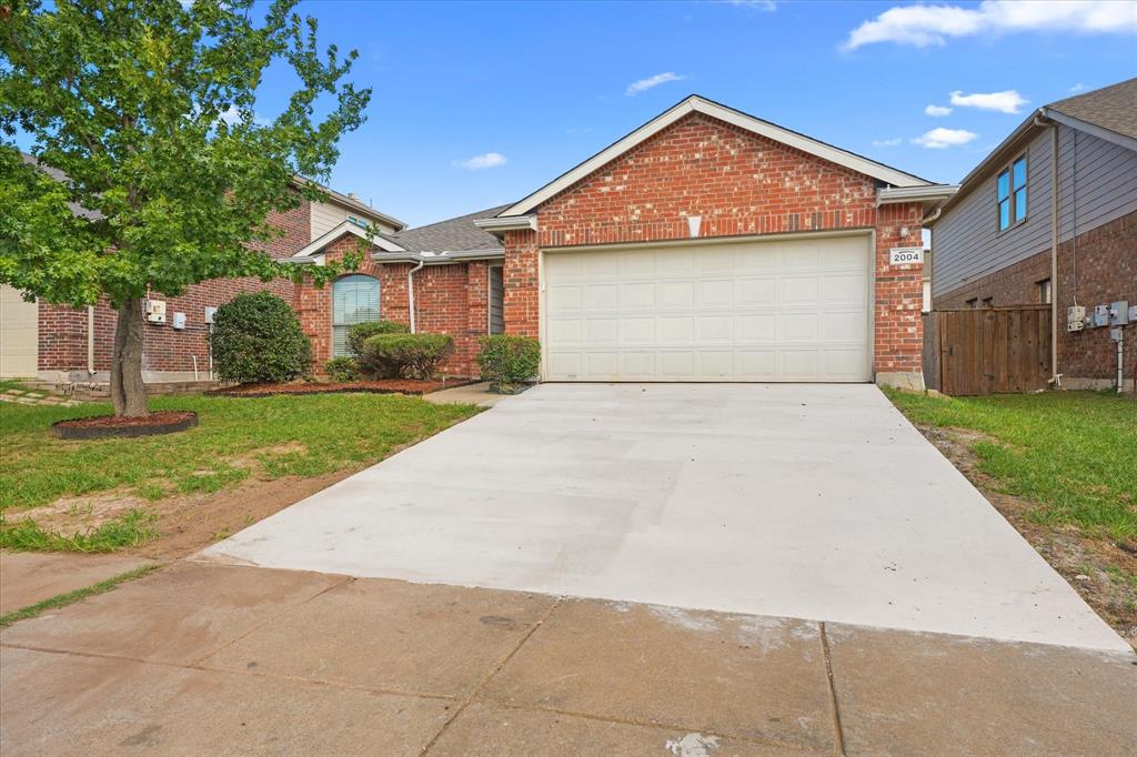 Single-story brick exterior featuring an attached two-car garage, concrete driveway, and established landscaping Single-story brick exterior featuring an attached two-car garage, concrete driveway, and established landscaping