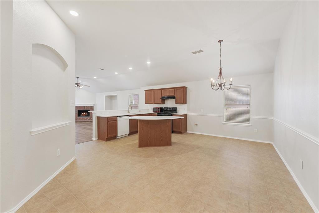 Kitchen featuring wood cabinetry, a central island with a white countertop, recessed lighting, and a multi-light chandelier Kitchen featuring wood cabinetry, a central island with a white countertop, recessed lighting, and a multi-light chandelier