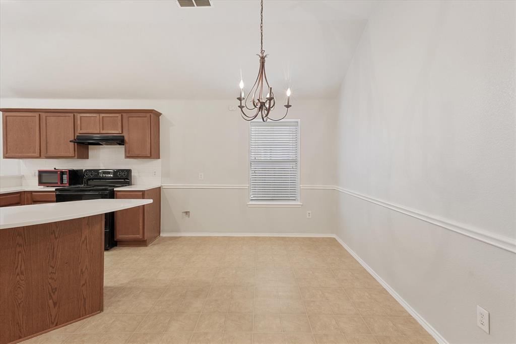 Vaulted ceiling, wood-finish cabinetry, central chandelier lighting, and decorative wall molding Vaulted ceiling, wood-finish cabinetry, central chandelier lighting, and decorative wall molding