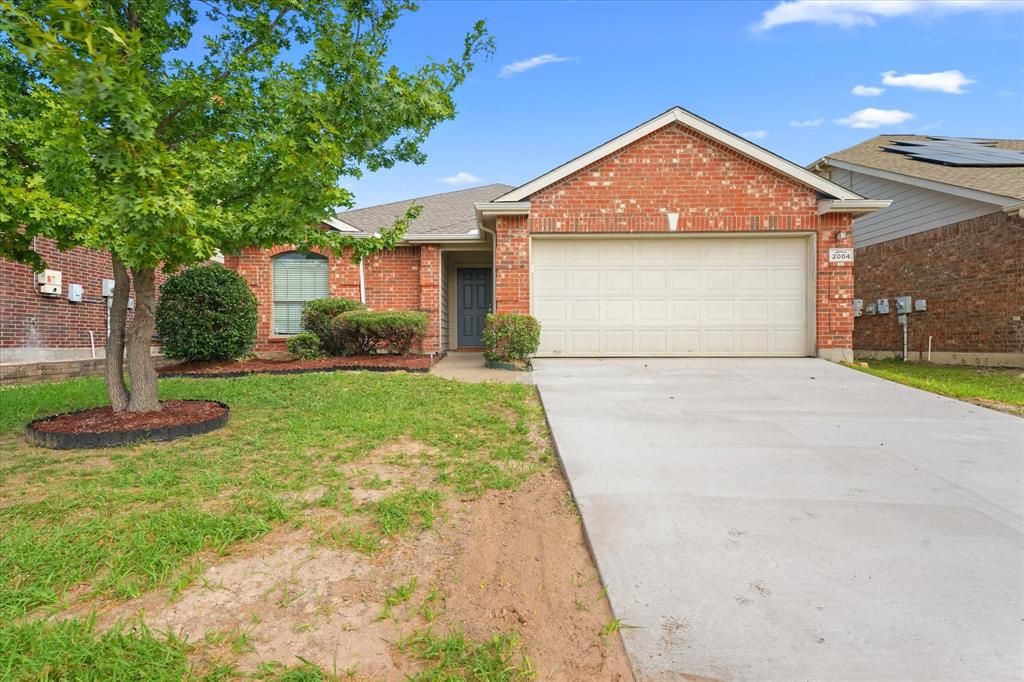 Brick exterior featuring a gabled roofline, concrete driveway, and attached two-car garage Brick exterior featuring a gabled roofline, concrete driveway, and attached two-car garage