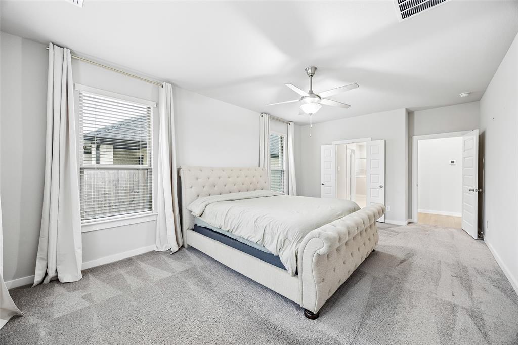 Neutral interior with wall-to-wall carpeting, ceiling fan, and paneled doors