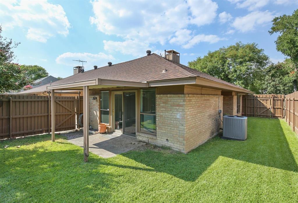 Brick exterior, covered patio, fenced backyard, and shingle roof
