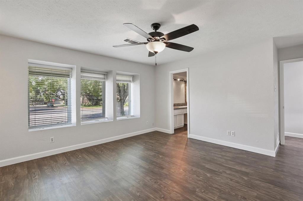 Wood-finish flooring, triple-pane window configuration, and a central ceiling fan with integrated lighting