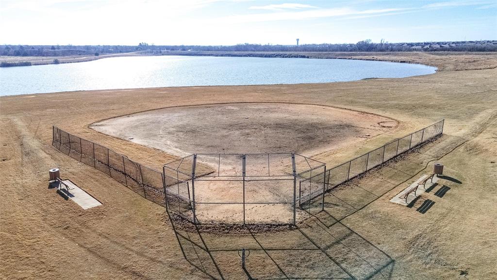 Baseball diamond featuring perimeter chain-link fencing, bench seating, and water frontage