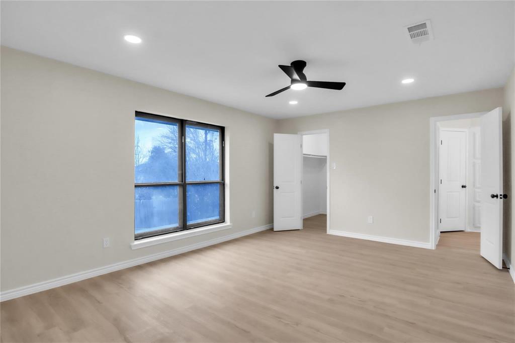 Room featuring wood-finish flooring, recessed lighting, a modern ceiling fan, and multiple interior doors