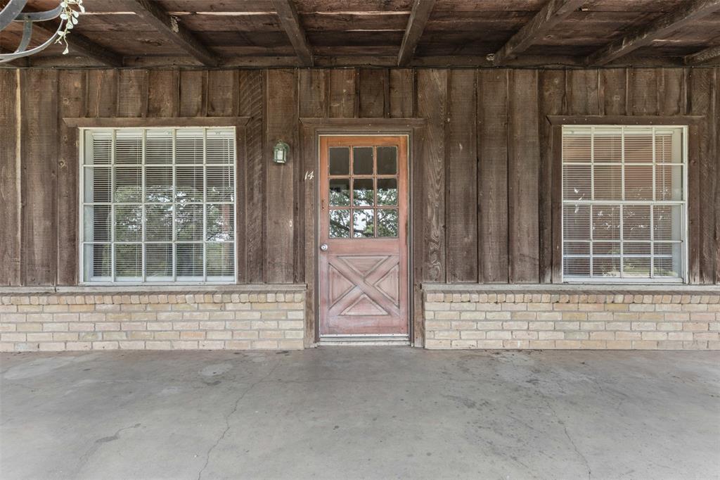 View of exterior entry featuring board and batten siding and brick siding