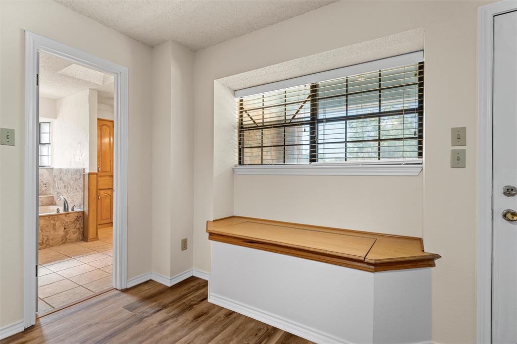 Primary bedroom entrance to bathroom and built in seating with storage