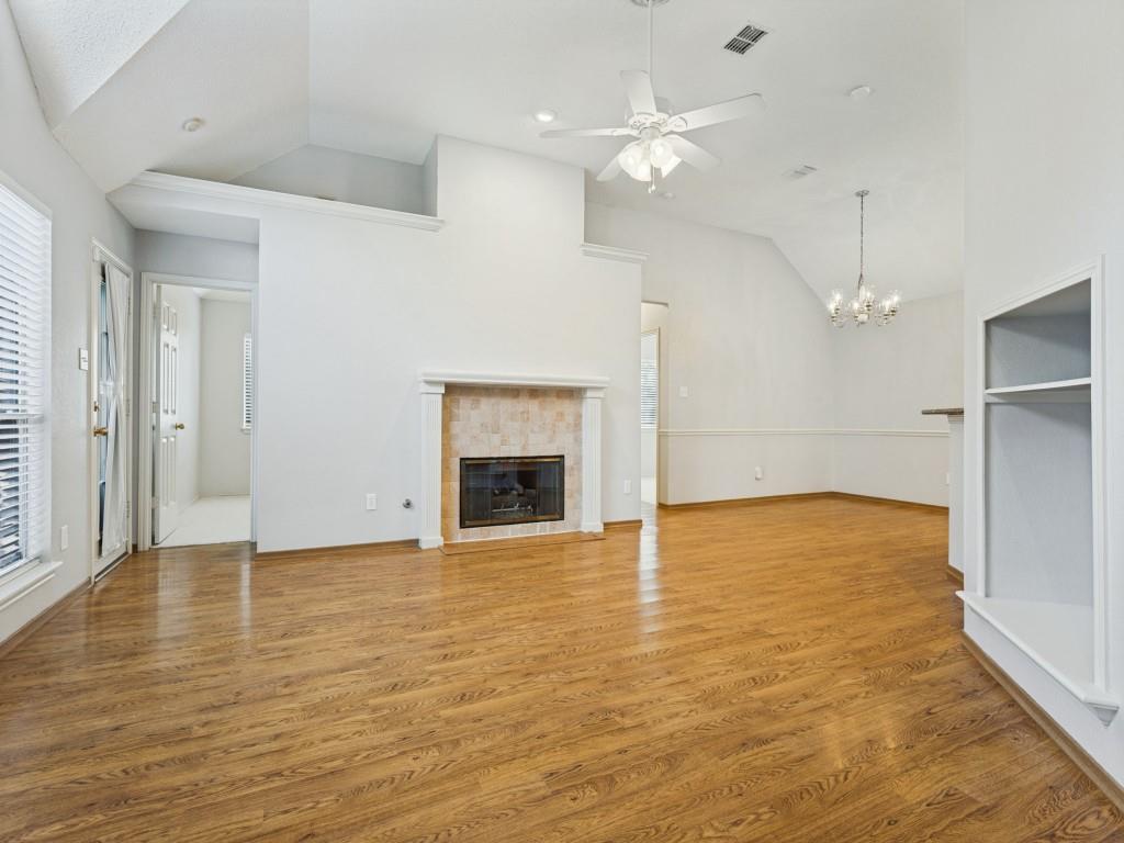 Vaulted ceilings, laminate flooring, masonry fireplace with a classic mantel, built-in recessed shelving, and a combination of recessed and decorative chandelier lighting Vaulted ceilings, laminate flooring, masonry fireplace with a classic mantel, built-in recessed shelving, and a combination of recessed and decorative chandelier lighting