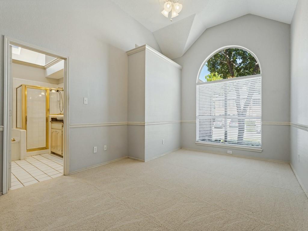 Vaulted ceiling with an arched window, neutral wall-to-wall carpeting, and a built-in light fixture Vaulted ceiling with an arched window, neutral wall-to-wall carpeting, and a built-in light fixture