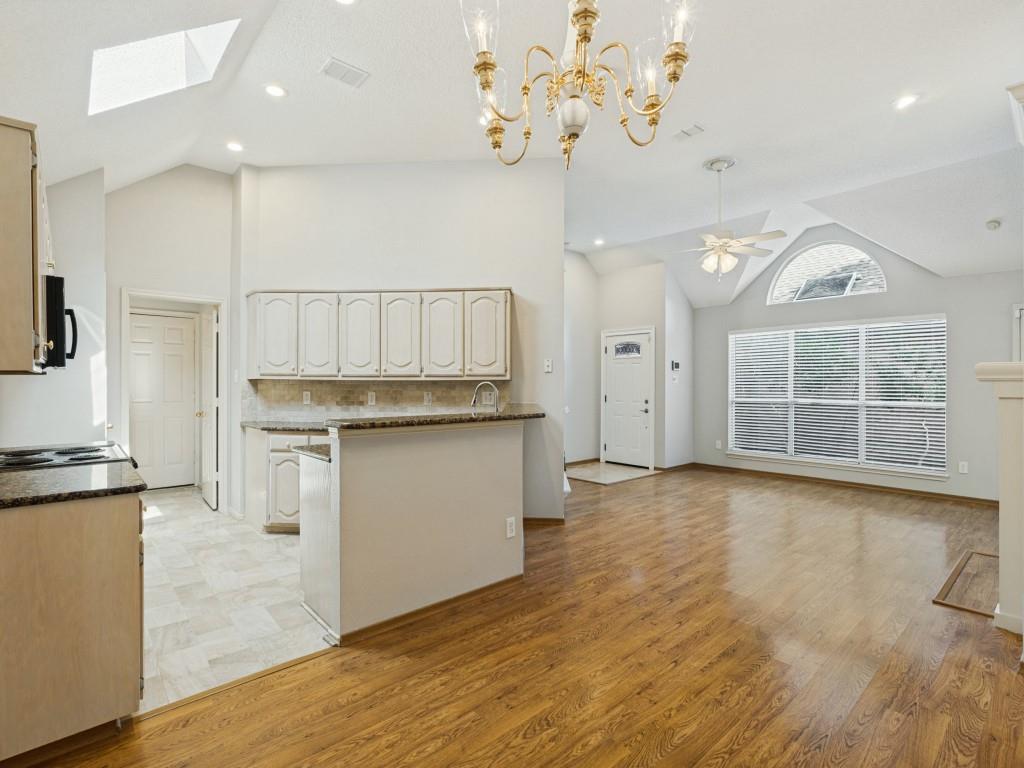 Vaulted ceilings, laminate flooring, arched window detailing, granite countertops, and ornate chandelier lighting Vaulted ceilings, laminate flooring, arched window detailing, granite countertops, and ornate chandelier lighting