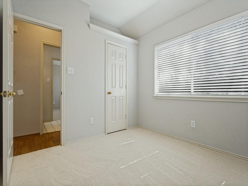 Neutral interior room featuring neutral-toned carpeting, a horizontal window with slatted blinds Neutral interior room featuring neutral-toned carpeting, a horizontal window with slatted blinds