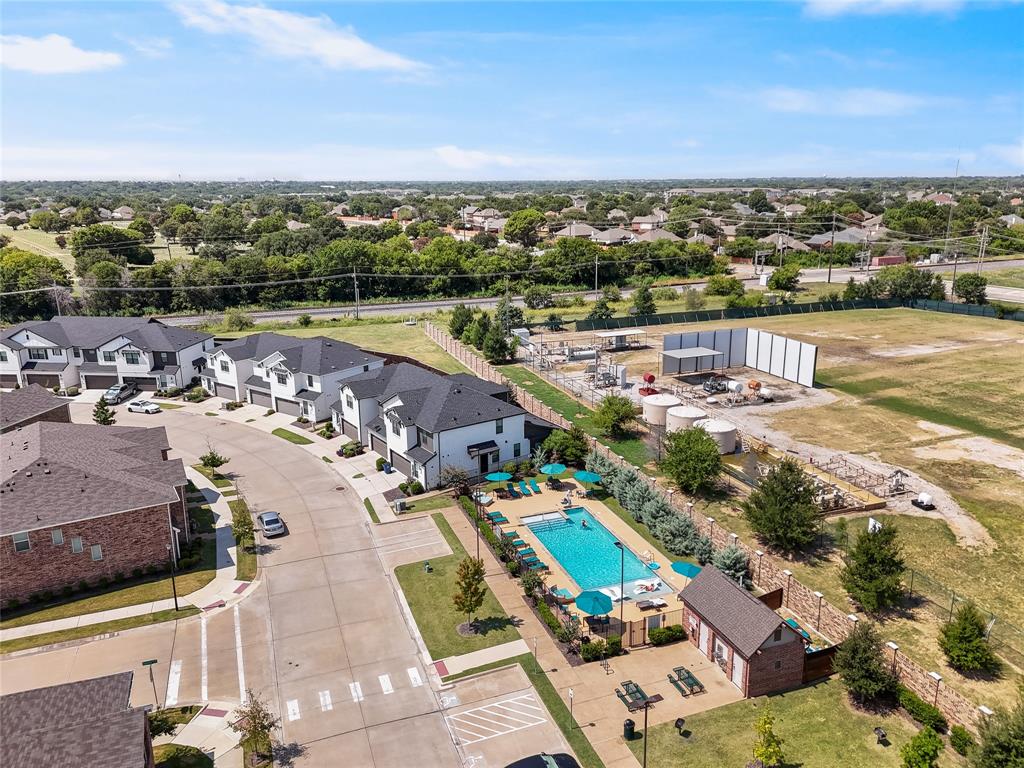 Community recreational area featuring a swimming pool, paved patio space, and a masonry-constructed clubhouse