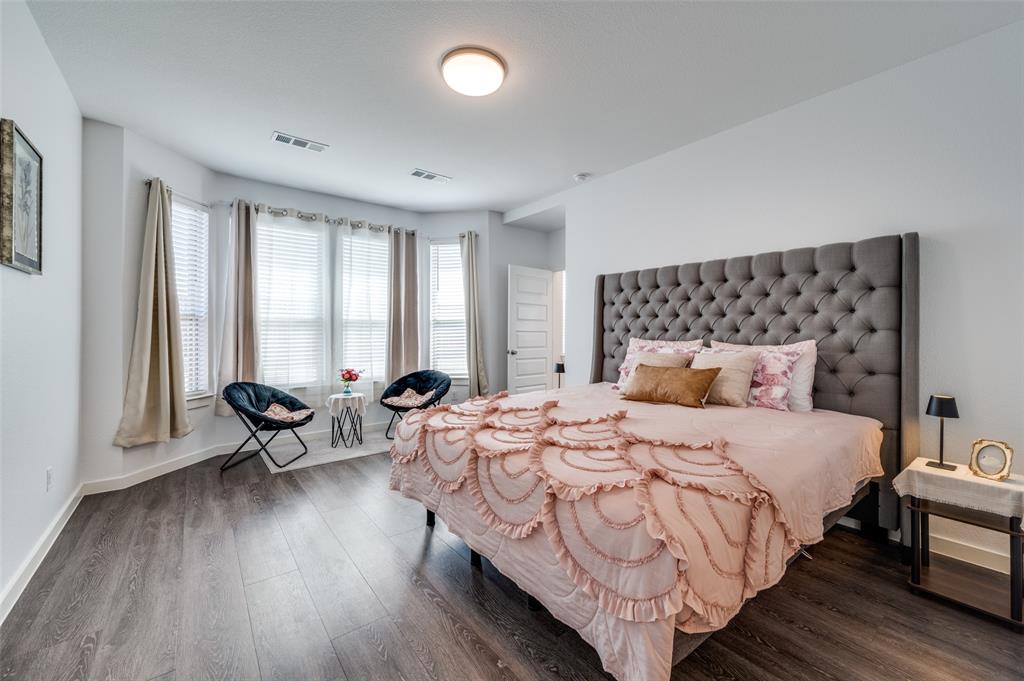 Bedroom featuring dark wood finished floors and baseboards
