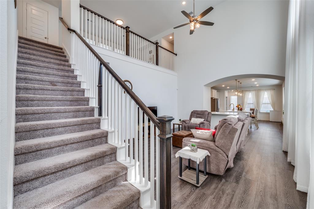 Living room featuring wood finished floors, arched walkways, a high ceiling, recessed lighting, and ceiling fan