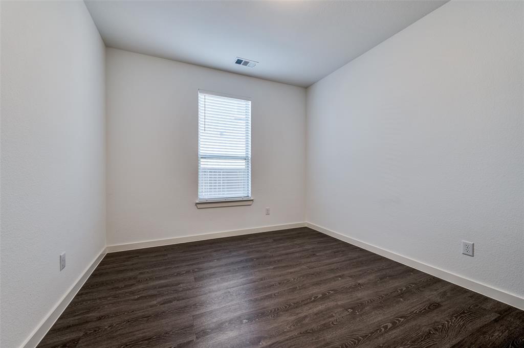 Spare room featuring dark wood finished floors and baseboards