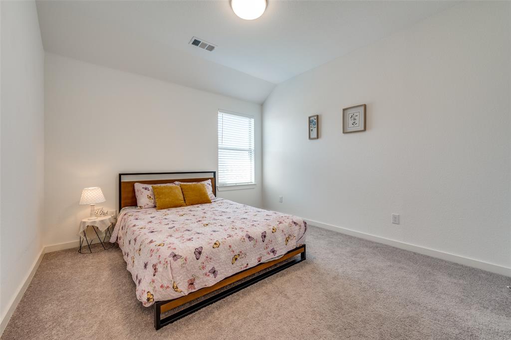 Carpeted bedroom featuring lofted ceiling and baseboards
