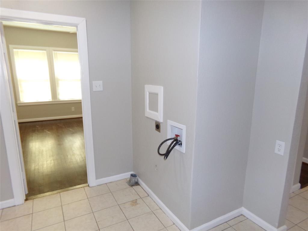 Utility area featuring ceramic tile flooring, neutral wall paint, and dedicated washer and dryer hookups