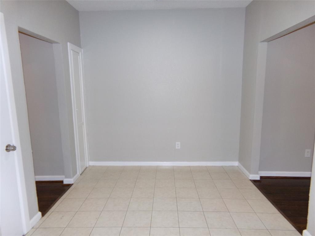 Neutral-toned interior space featuring light-colored ceramic tile flooring, solid-core doors, and recessed doorways