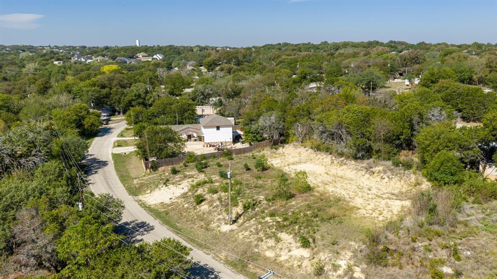 Expansive lot featuring mature trees and significant natural vegetation, situated along a paved road