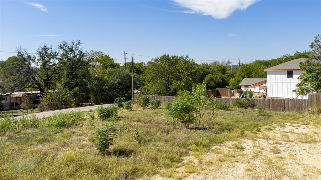 Expansive lot featuring native vegetation, mature trees, and wooden perimeter fencing