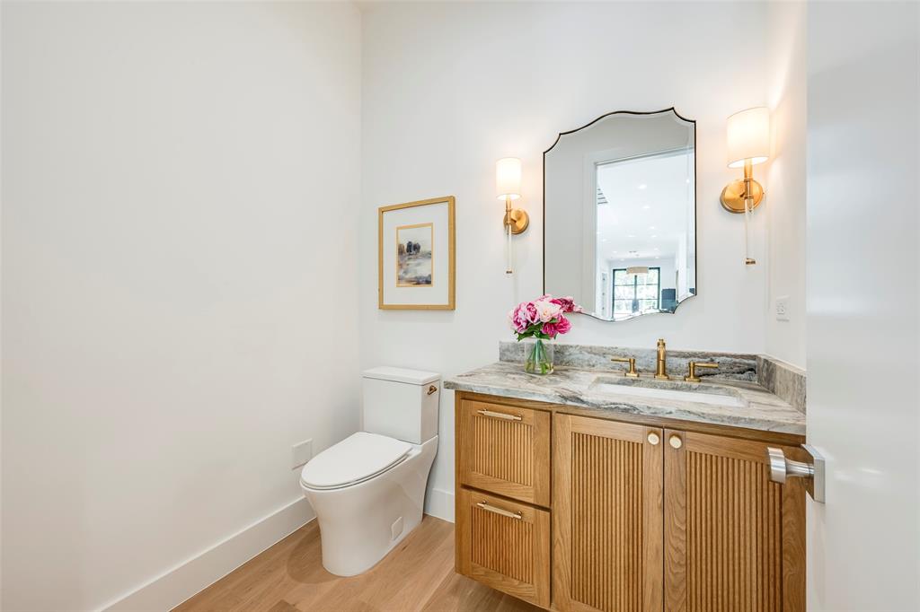 Powder bath off the living area with custom solid white oak fluted vanity and quartzite countertop.
