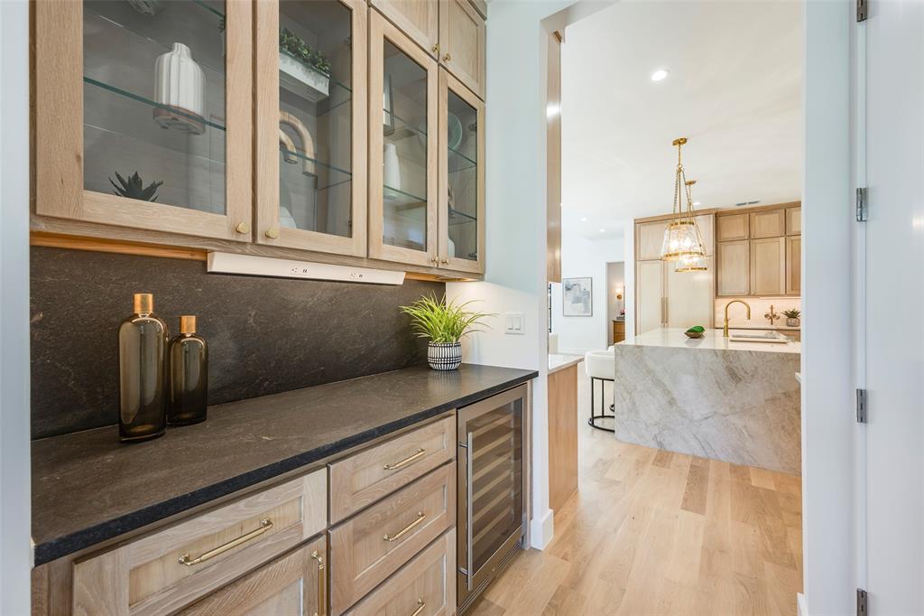Butlers pantry with wine fridge and walk-in pantry separates dining room from kitchen.
