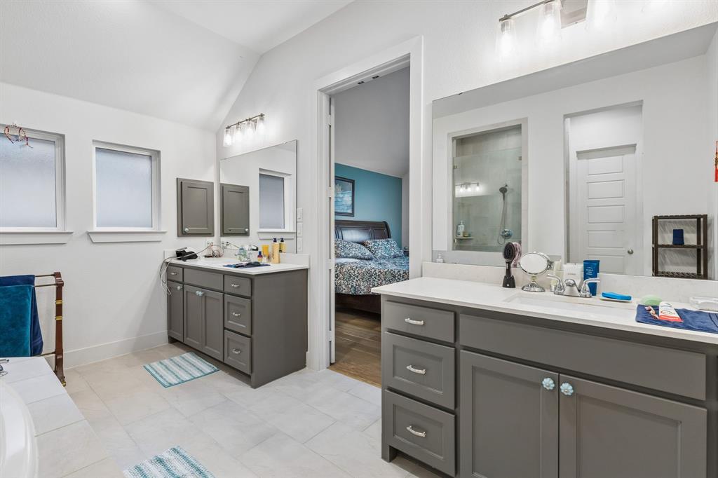Dual vanity cabinets featuring gray finish, white countertops, rectangular undermount sinks, and wall-to-wall mirrors