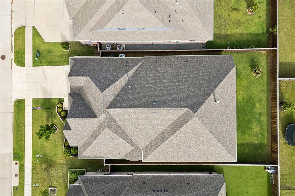 Aerial perspective of property featuring a multi-gabled asphalt shingle roof and a fenced backyard