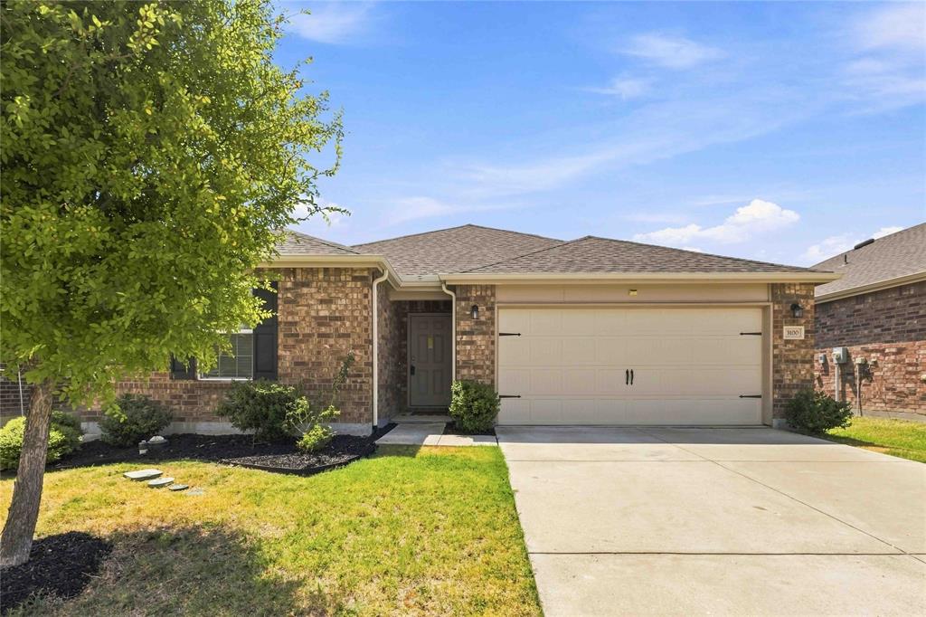 Single-story brick exterior featuring an attached two-car garage, asphalt shingle roof, and a concrete driveway