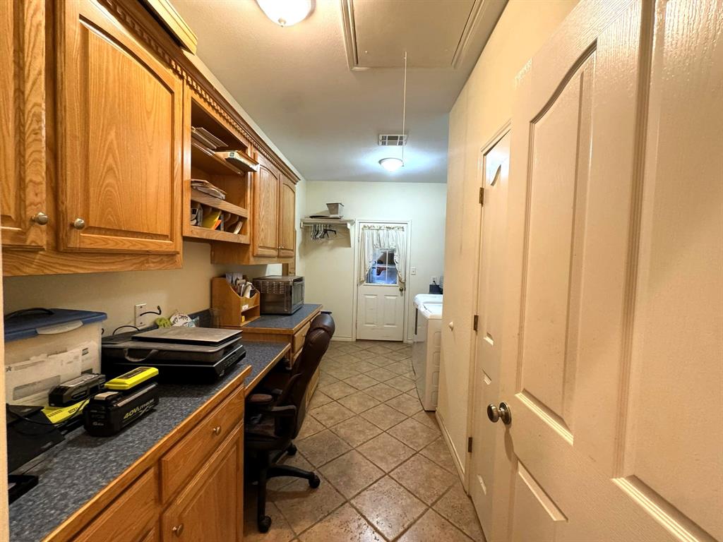 Built-in wood cabinetry, extended laminate countertop, and ceramic tile flooring