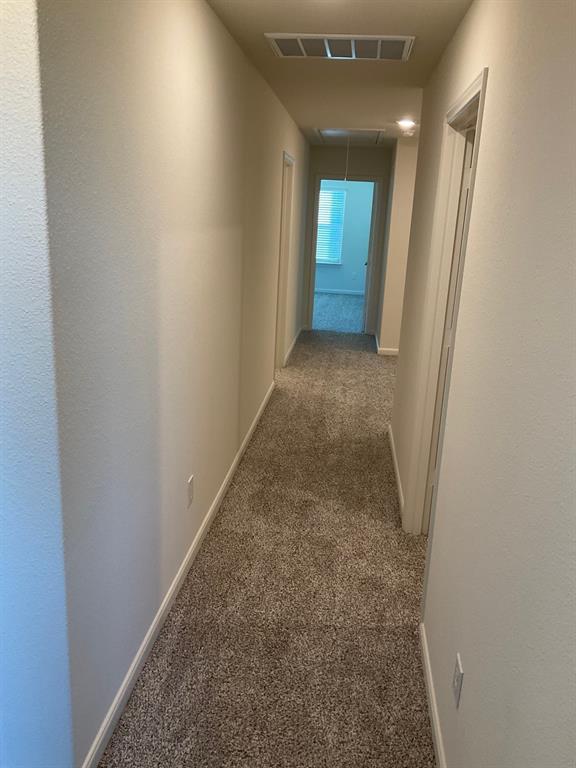 Hallway featuring neutral wall paint, textured carpeting, and recessed ceiling lighting