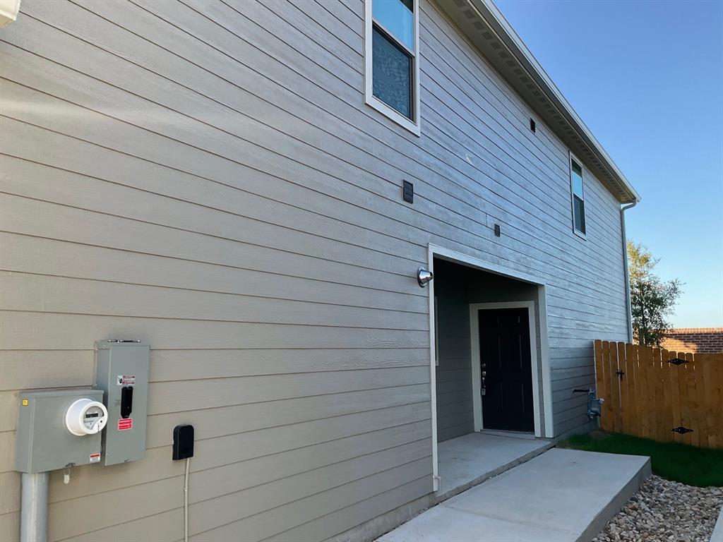 Horizontal lap siding exterior featuring a covered entryway, concrete patio, and fenced perimeter