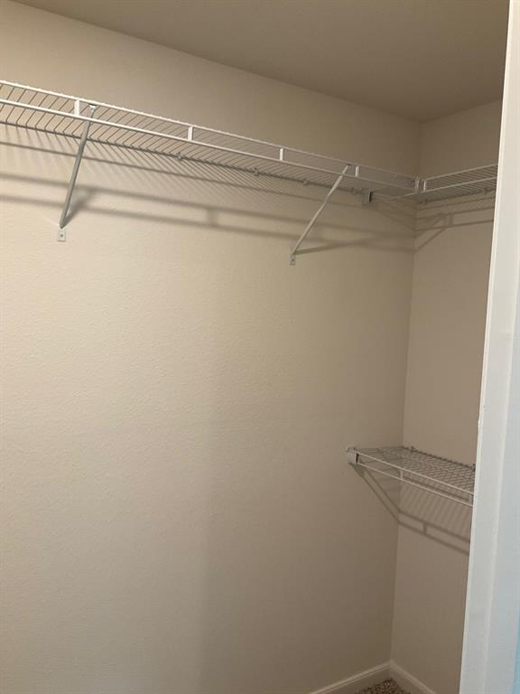 Walk-in storage space featuring multi-level white wire shelving