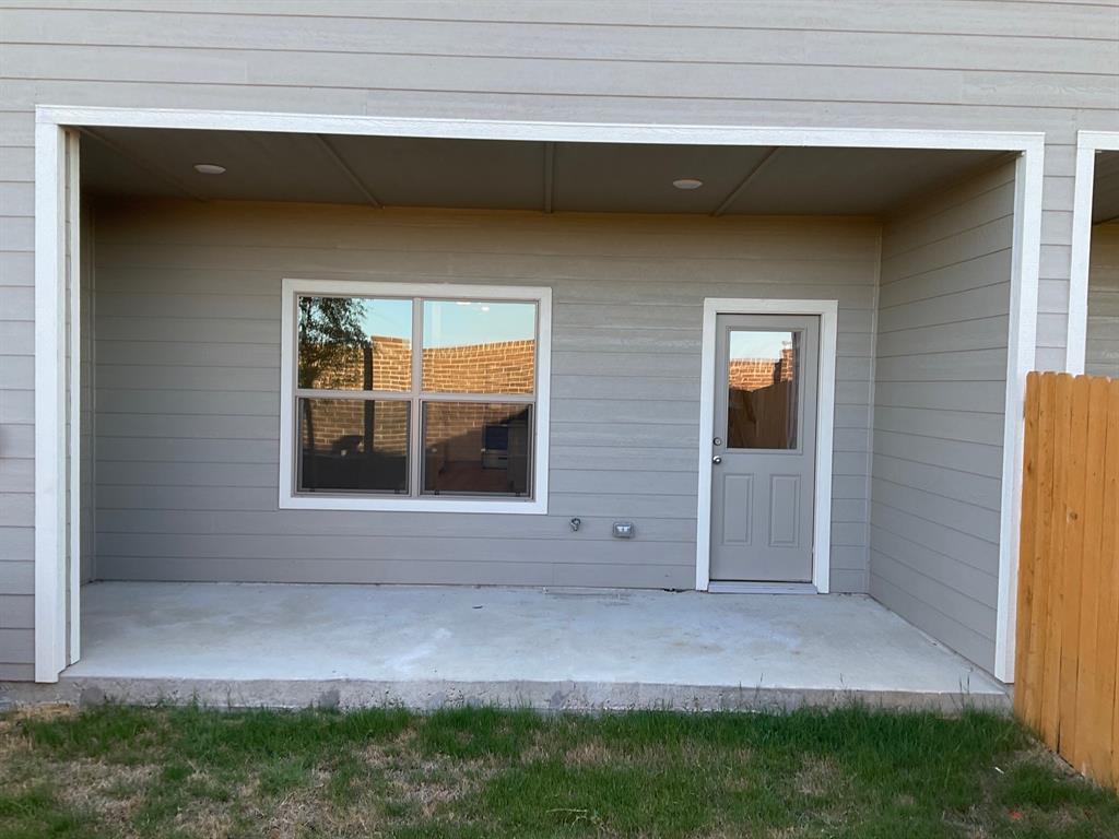 Covered concrete patio featuring horizontal lap siding, recessed ceiling lighting, a single-pane window with white trim, and a glass-panel exterior door