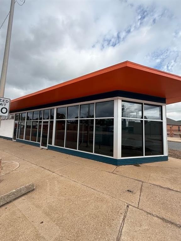 expansive wrap-around storefront window system, prominent overhanging roofline, and durable siding expansive wrap-around storefront window system, prominent overhanging roofline, and durable siding