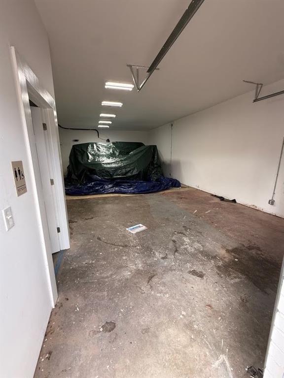 Enclosed garage area featuring white interior walls and recessed linear lighting