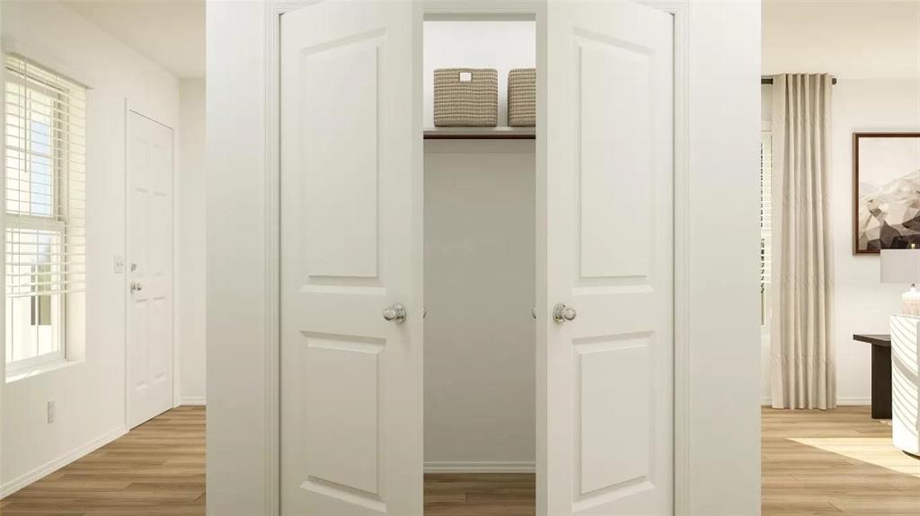 Double-door closet featuring a built-in shelf, metal hanging rod, and wood-finish flooring throughout