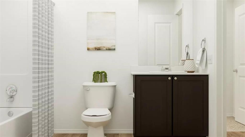 Bathroom featuring a dark-finish vanity with a light-toned countertop, integrated basin, chrome-finished plumbing fixtures, and a shower-tub combination with a white surround