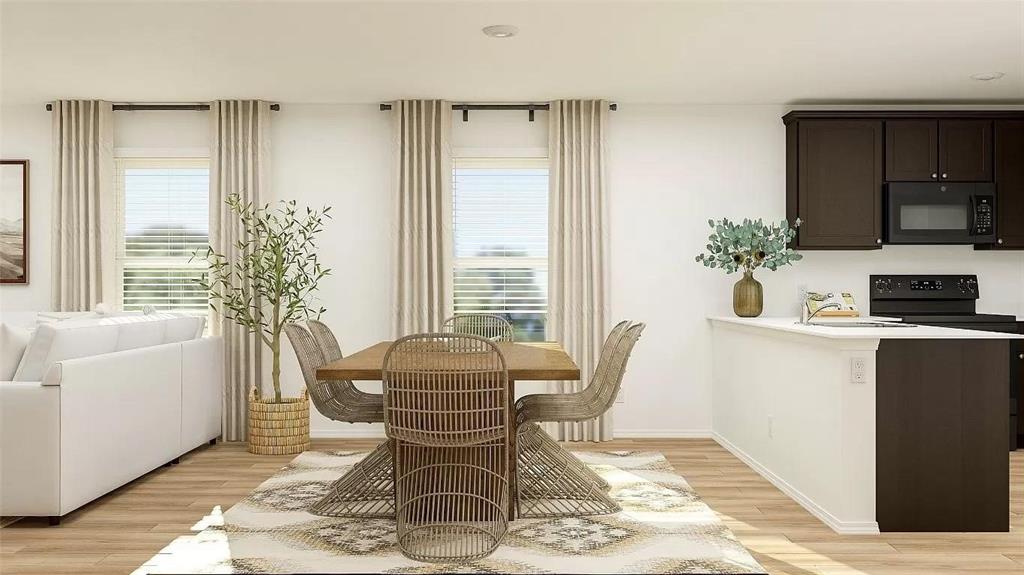 Open-concept living space featuring wood-finish flooring, recessed lighting, and a kitchen equipped with dark cabinetry, a built-in microwave, and a peninsula with countertop seating Open-concept living space featuring wood-finish flooring, recessed lighting, and a kitchen equipped with dark cabinetry, a built-in microwave, and a peninsula with countertop seating