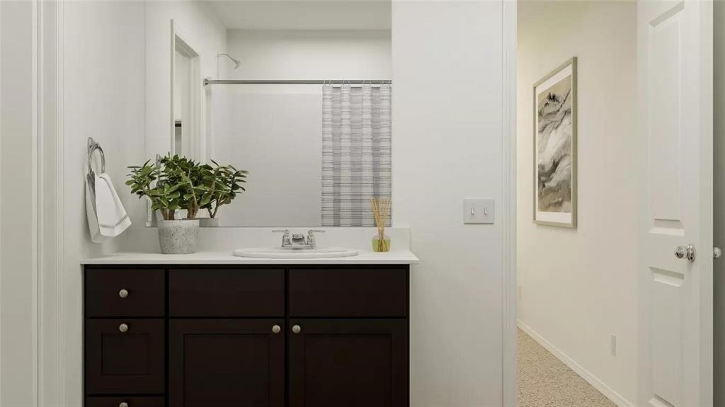 Dark-finish vanity cabinetry with brushed metal hardware, white solid-surface countertop, integrated basin, and large vanity mirror