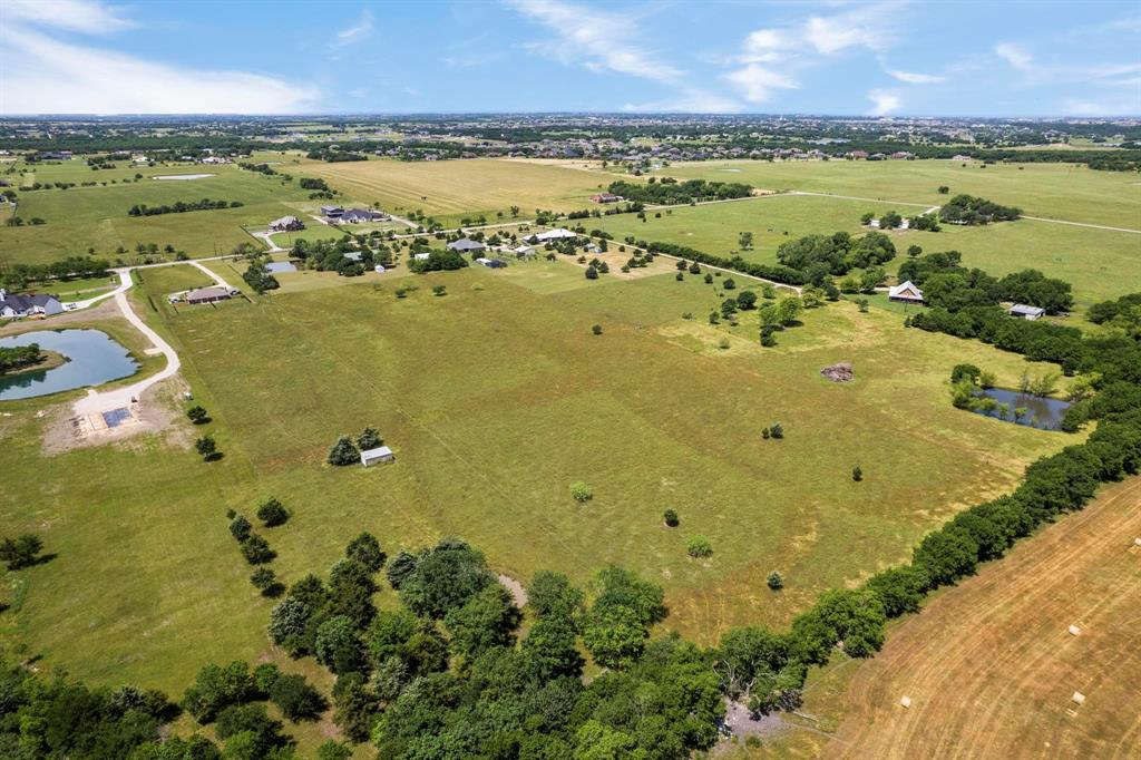 Expansive acreage featuring cleared pastureland, mature trees, and multiple bodies of water