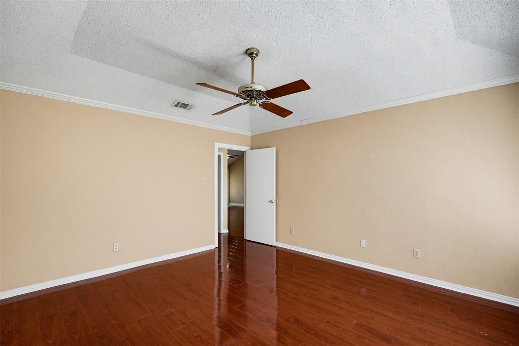 Vaulted ceiling featuring a ceiling fan, polished wood-finish flooring, and crown molding