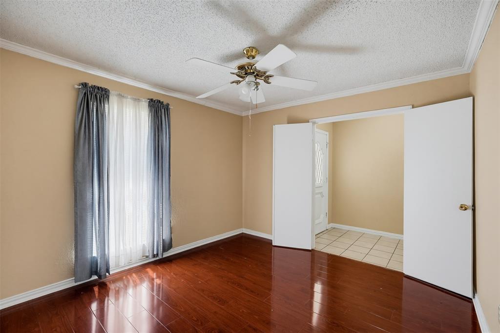 Room featuring wood-finish flooring, a ceiling fan with integrated lighting, and crown molding