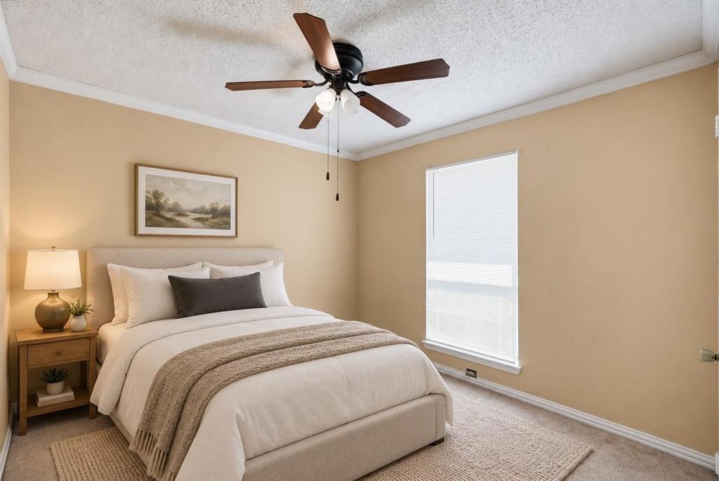 Room featuring a ceiling fan with integrated lighting, neutral wall paint, crown molding, and a tall window