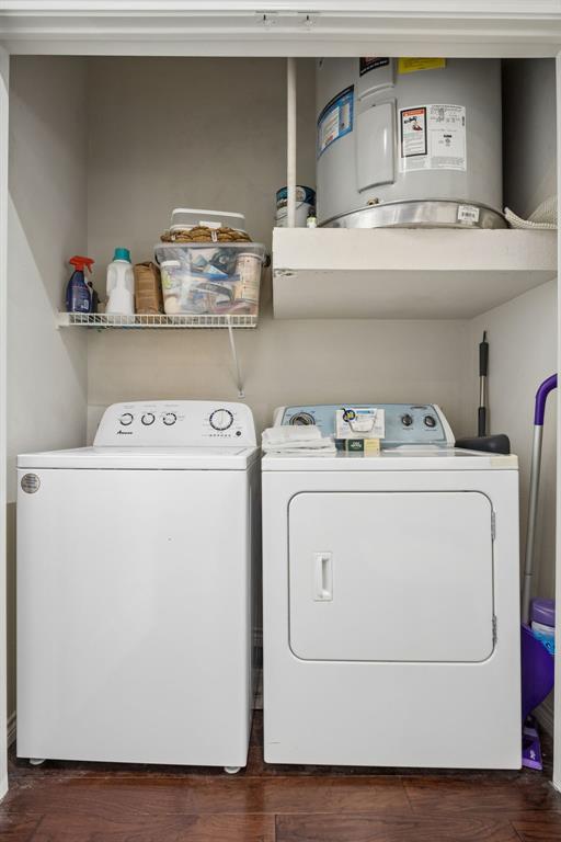 Dedicated laundry closet featuring a top-load washing machine, front-load dryer, and wood-finish flooring