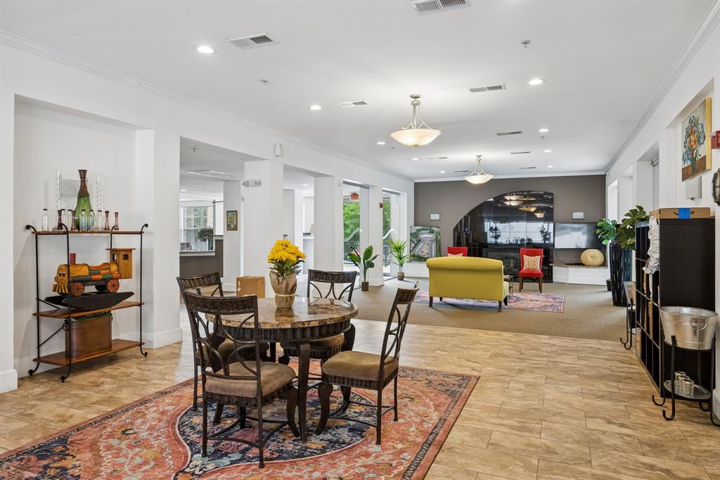 Spacious common area featuring light-toned tile flooring, recessed lighting, and multiple pendant light fixtures