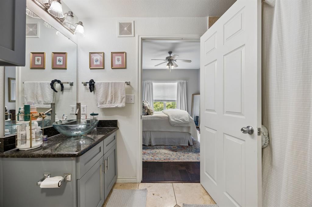 Bathroom featuring a gray vanity with a dark countertop and a glass vessel sink