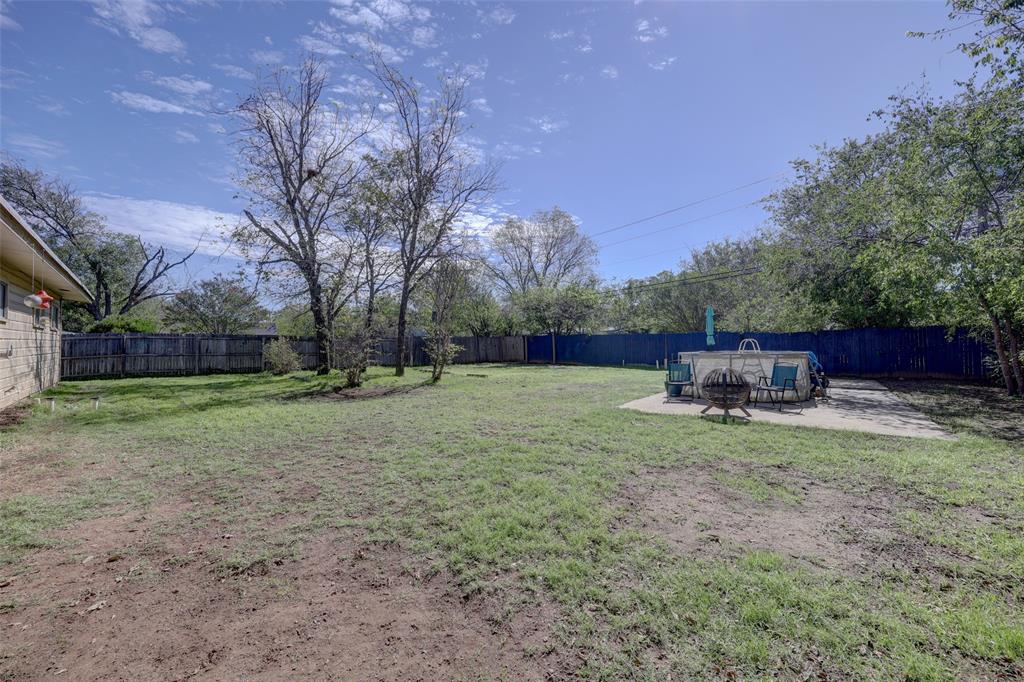 expansive back yard with above ground pool on concrete slab